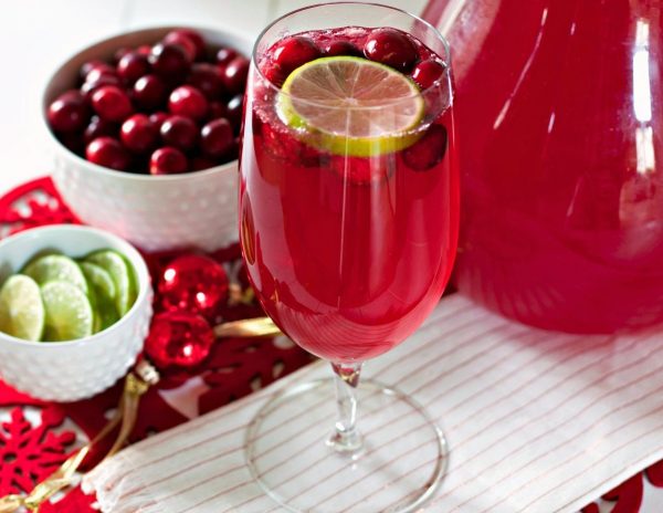 Cranberry mocktail garnished with fresh cranberries and lime slices. 