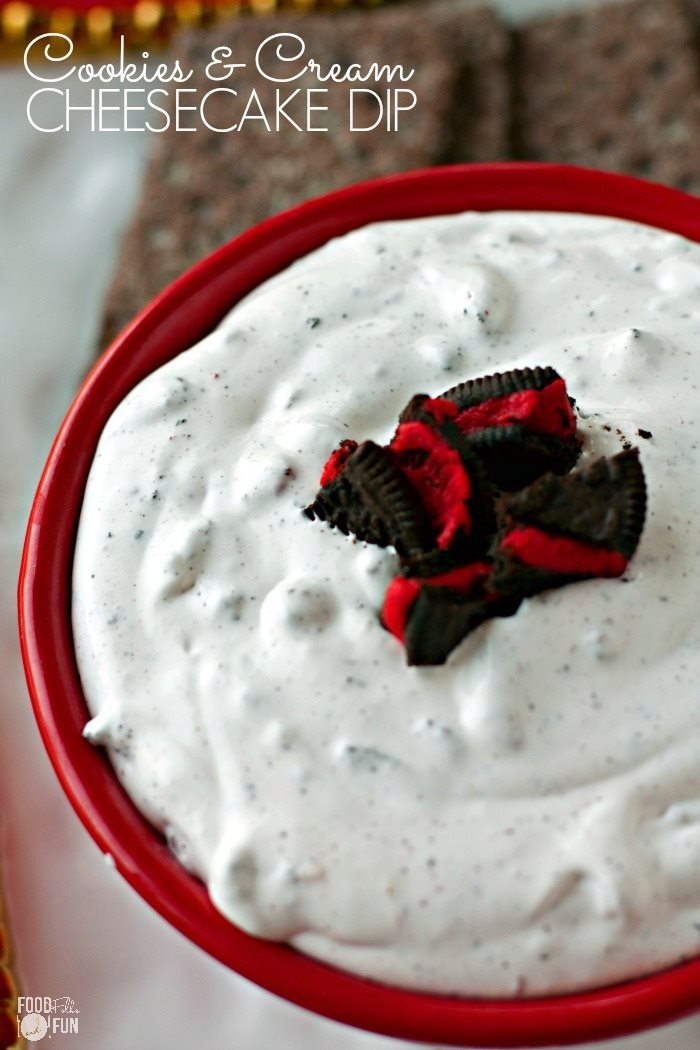 Close up picture of cookies and cream cheesecake dip in a red bowl that is garnished with broken cookies. 