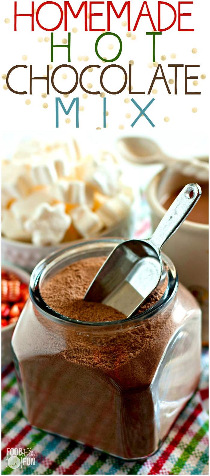 Hot chocolate mix in a glass jar with a metal scoop. 