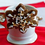 Gingerbread Cookie hanging from the side of a cocoa cup