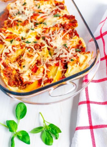 A pan full of stuffed shells and meat sauce.