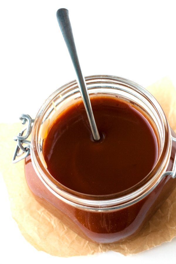 A spoon inside a jar of salted caramel. 