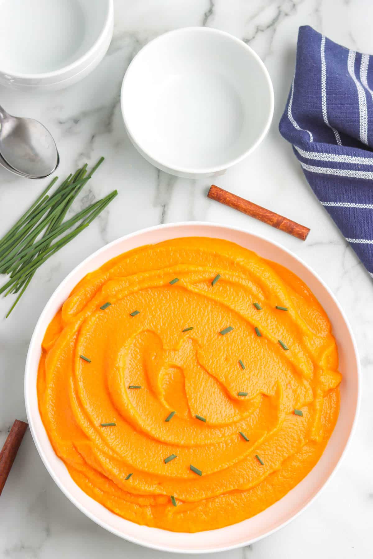 An overhead picture of pureed carrots in a white serving bowl.