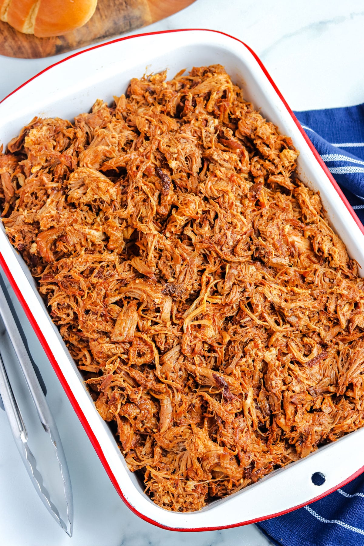 A 9x13 baking dish with the finished pulled pork in it.