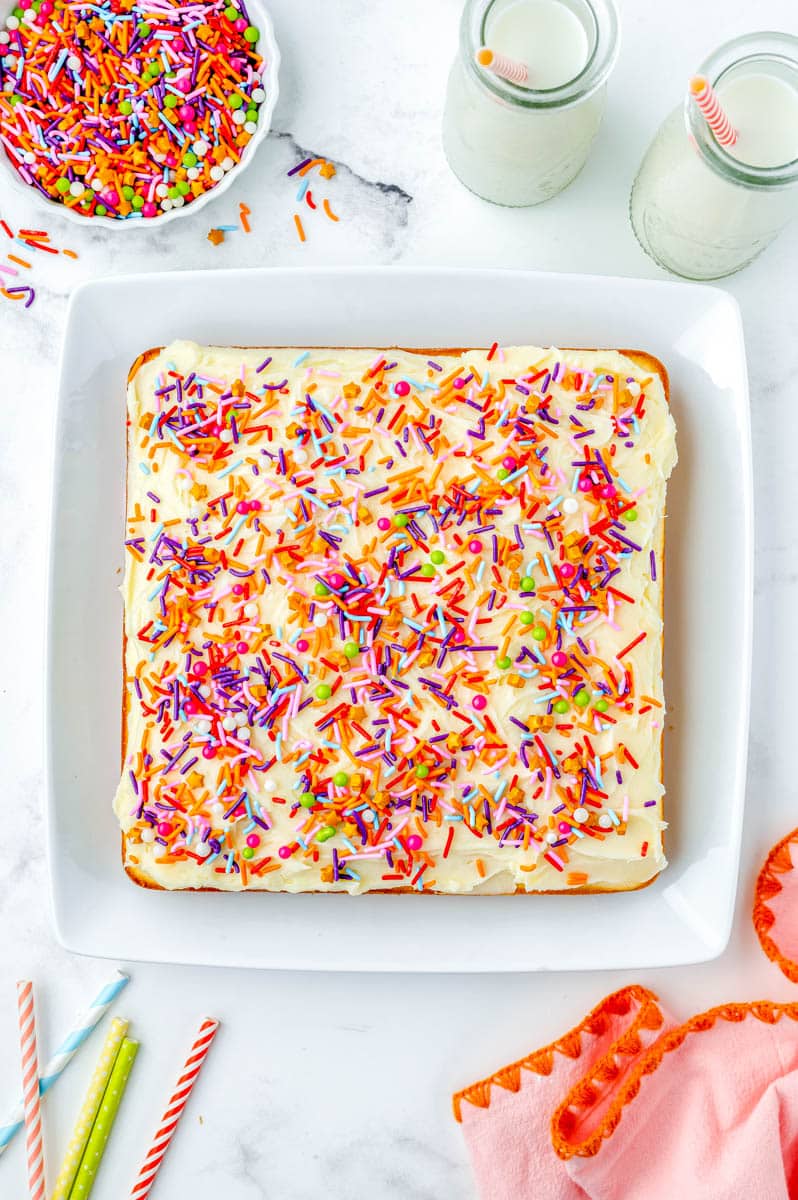 An overhead picture of the finished White Cake on a serving platter and covered in sprinkles. 