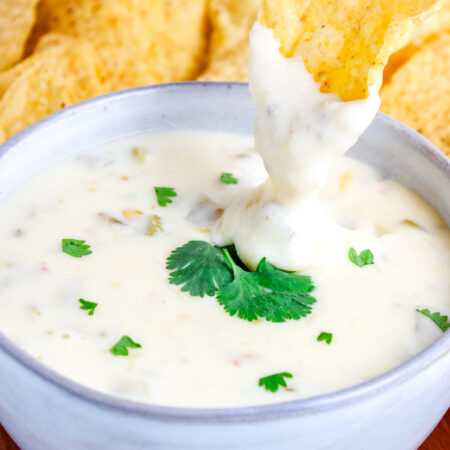 Creamy white queso dip served warm with tortilla chips.