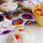 Two candy corn cookies on the counter with more on a wire rack