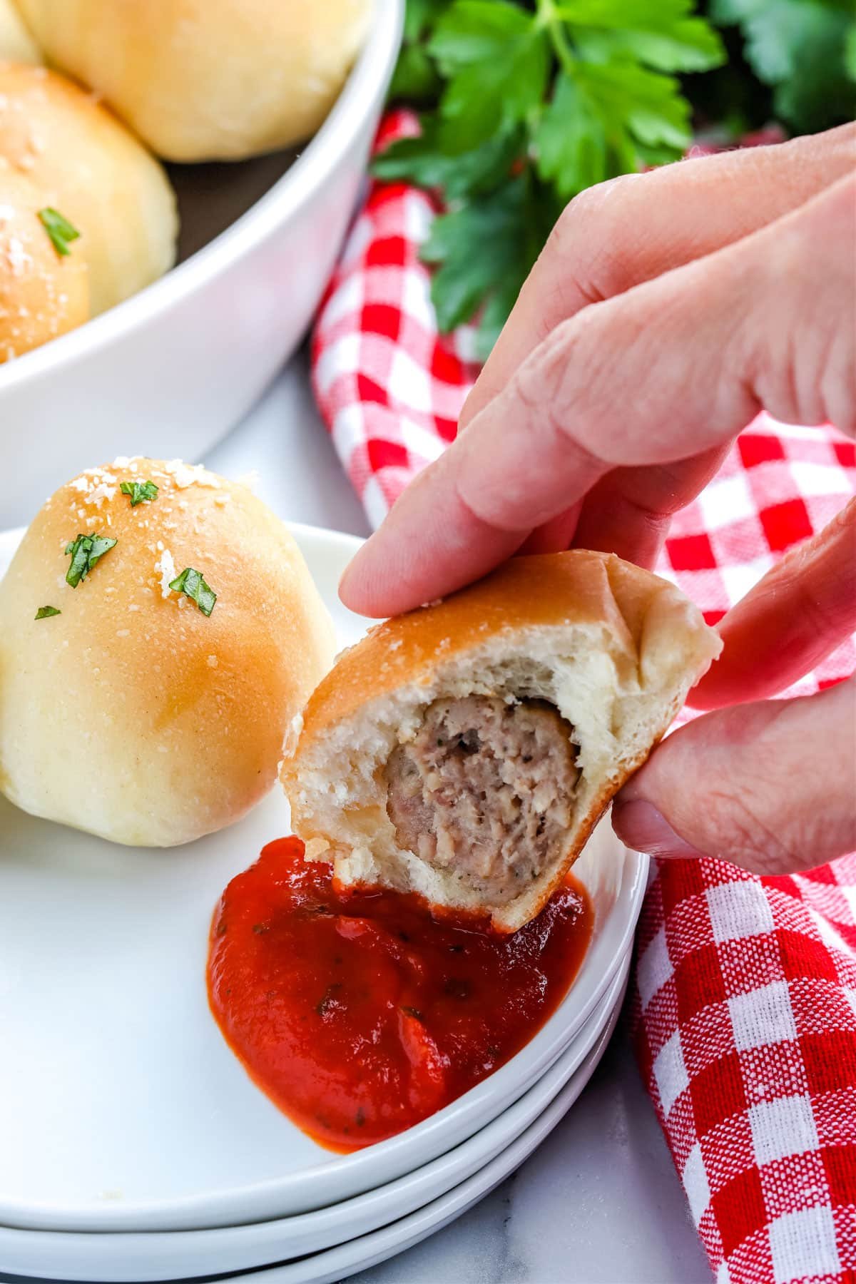 Up close of someone dipping the meatball bite into sauce.