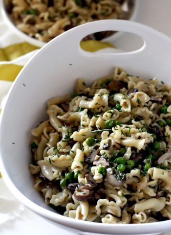 A bowl of Pasta with mushrooms, peas, and creamy camembert sauce