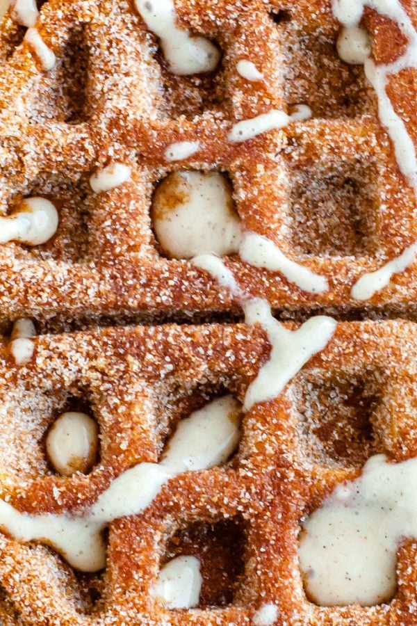 A close up overhead picture of the finished pumpkin churro waffles with cream cheese glaze.