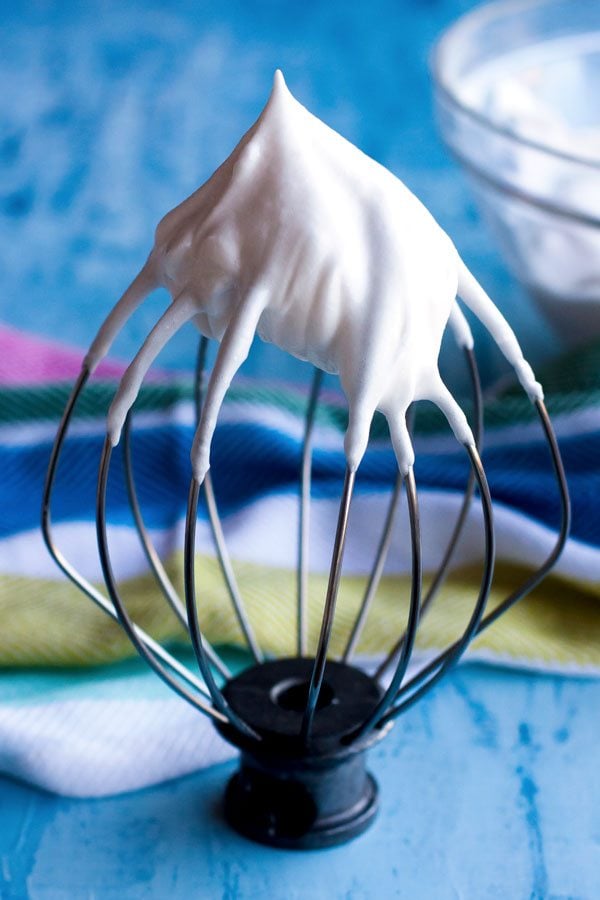 white frosting on a whisk attachment.