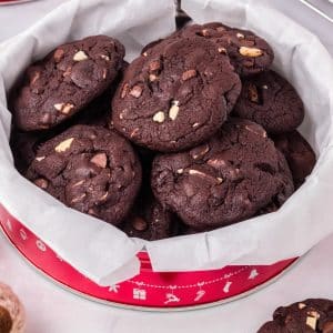 The finished Dark Chocolate Cherry Cookies recipe in a red gifting tin for Christmas.