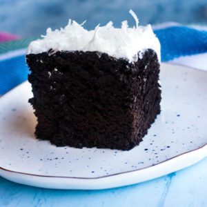 Chocolate cake on a plate with white 7 minute frosting.
