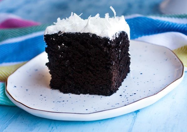 Chocolate cake on a plate with white 7 minute frosting.