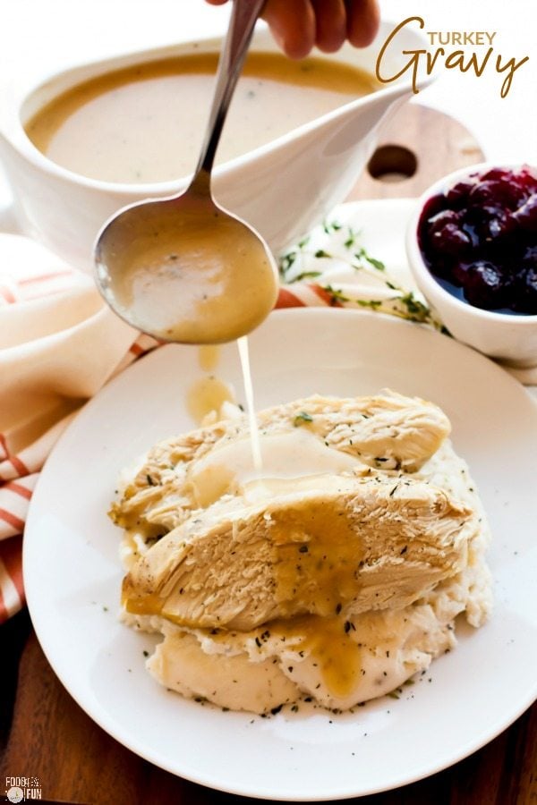 Gravy being poured over turkey and mashed potatoes.