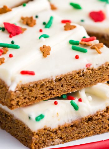 A close up picture of a gingerbread bar with cream cheese frosting and Christmas sprinkles.
