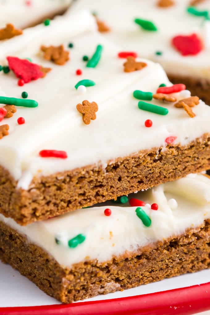 A close up picture of a gingerbread bar with cream cheese frosting and Christmas sprinkles.
