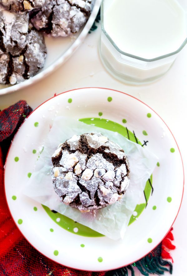 A chocolate crinkle cookie with hazelnuts on a plate