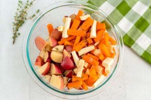 Place the chopped potatoes, carrots, and parsnips in a bowl.