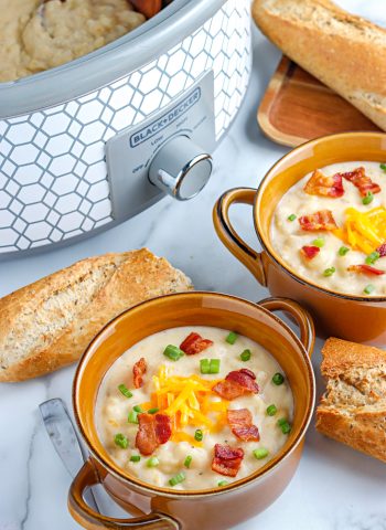 Slow Cooker Loaded Baked Potato Soup in soup bowls and in a Crockpot.