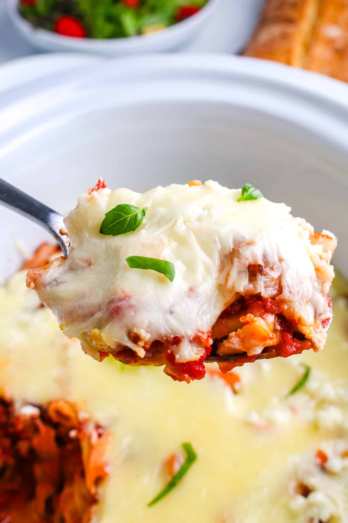 A scoop of baked ziti on a serving spoon.