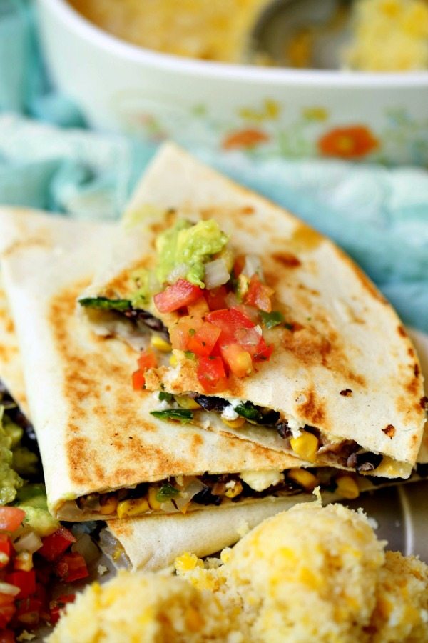 A veggie quesadilla topped with salsa and guacamole