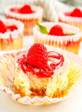 A finished Raspberry Cheesecake Cupcake with a bite taken out of it.
