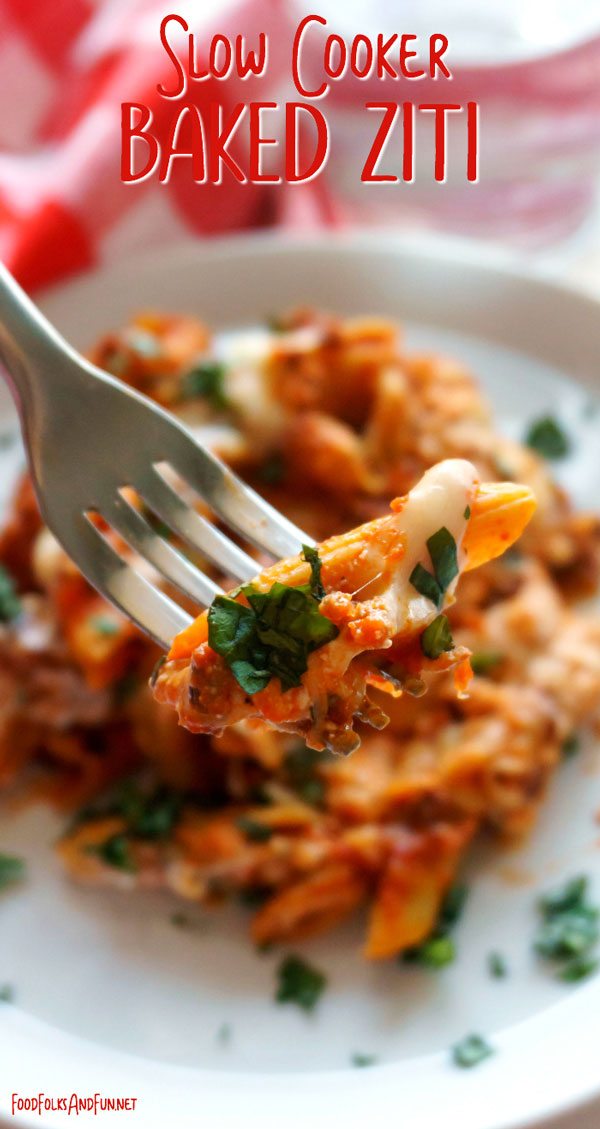 A bite of Baked Ziti with the remaining ziti in the background on a plate