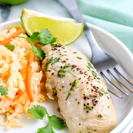 Easy cilantro chicken served with rice pilaf and lime wedges.