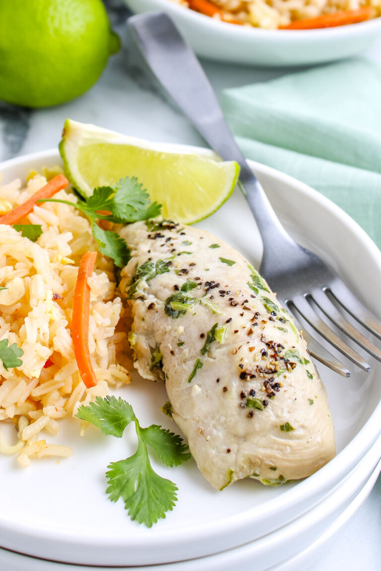 Easy cilantro chicken served with rice pilaf and lime wedges.