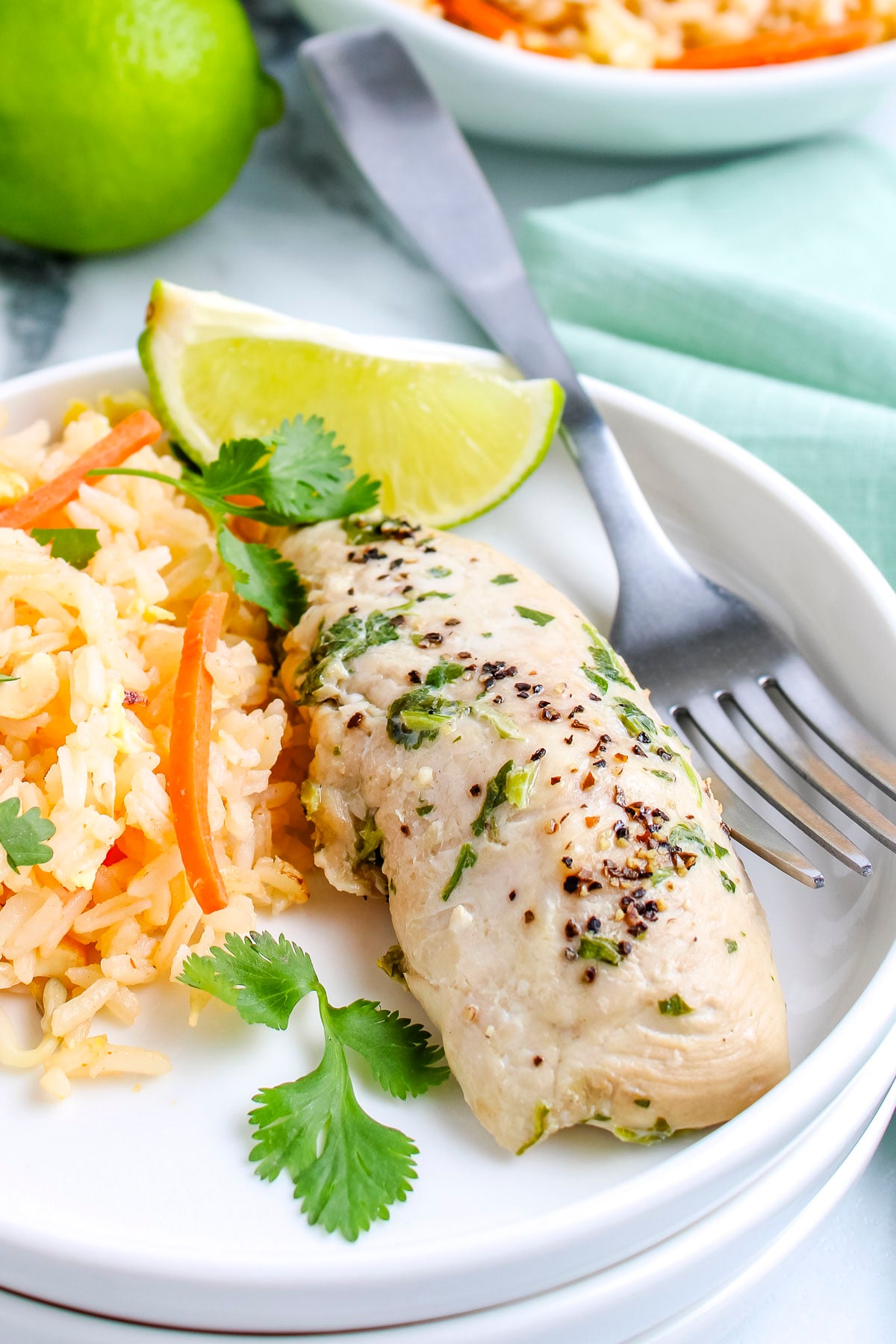 Easy cilantro chicken served with rice pilaf and lime wedges.