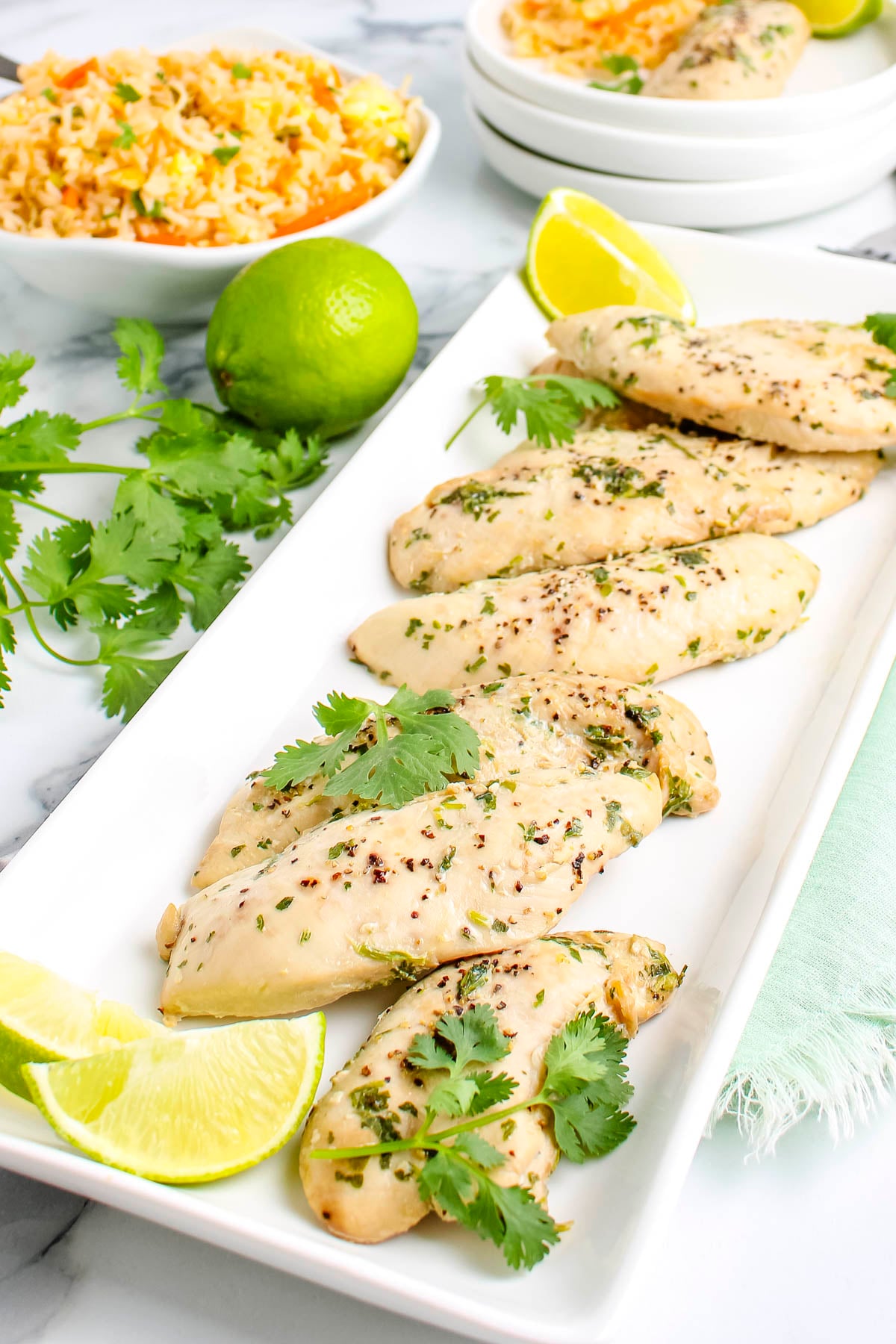 Thai-inspired cilantro chicken tenderloins garnished with fresh cilantro and lime slices.