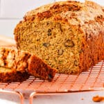 A loaf of my mothers zucchinni bread on a wire rack.