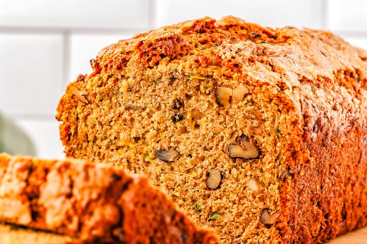 A loaf of Zucchini Bread with two slices cut from it.