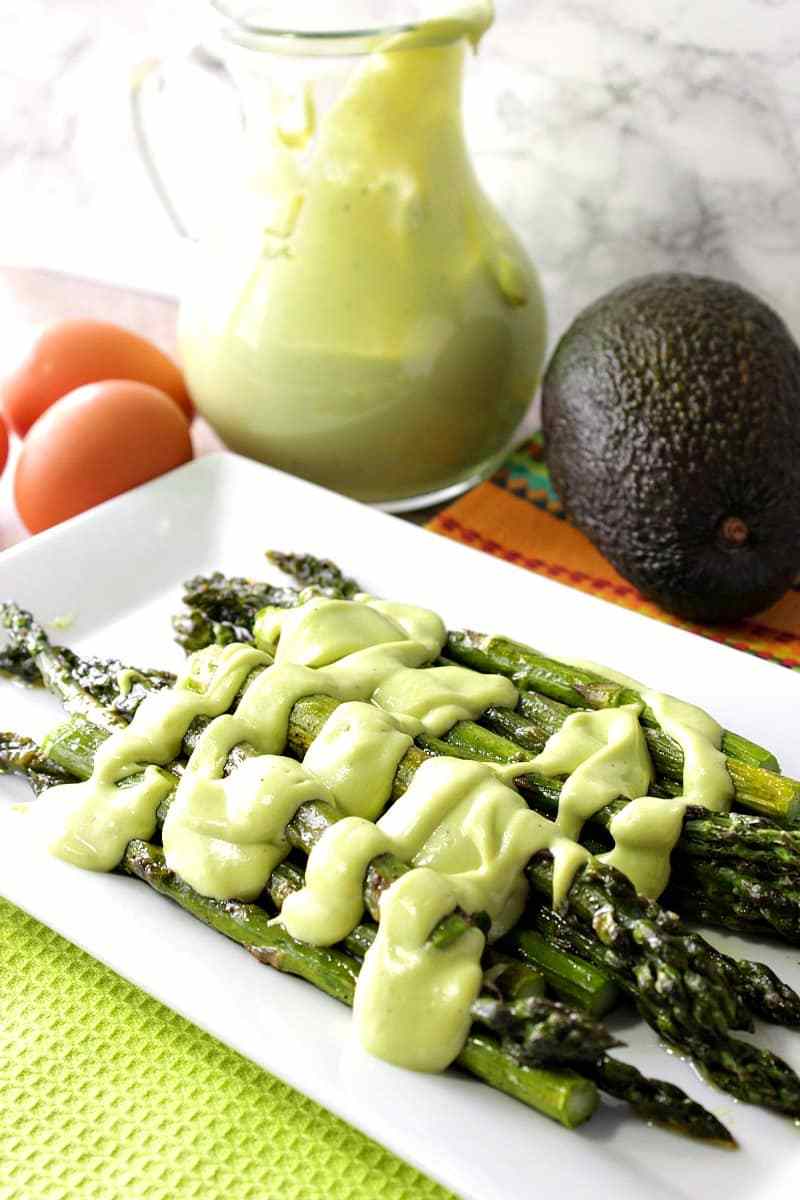 Roasted asparagus with avocado hollandaise sauce on a serving platter