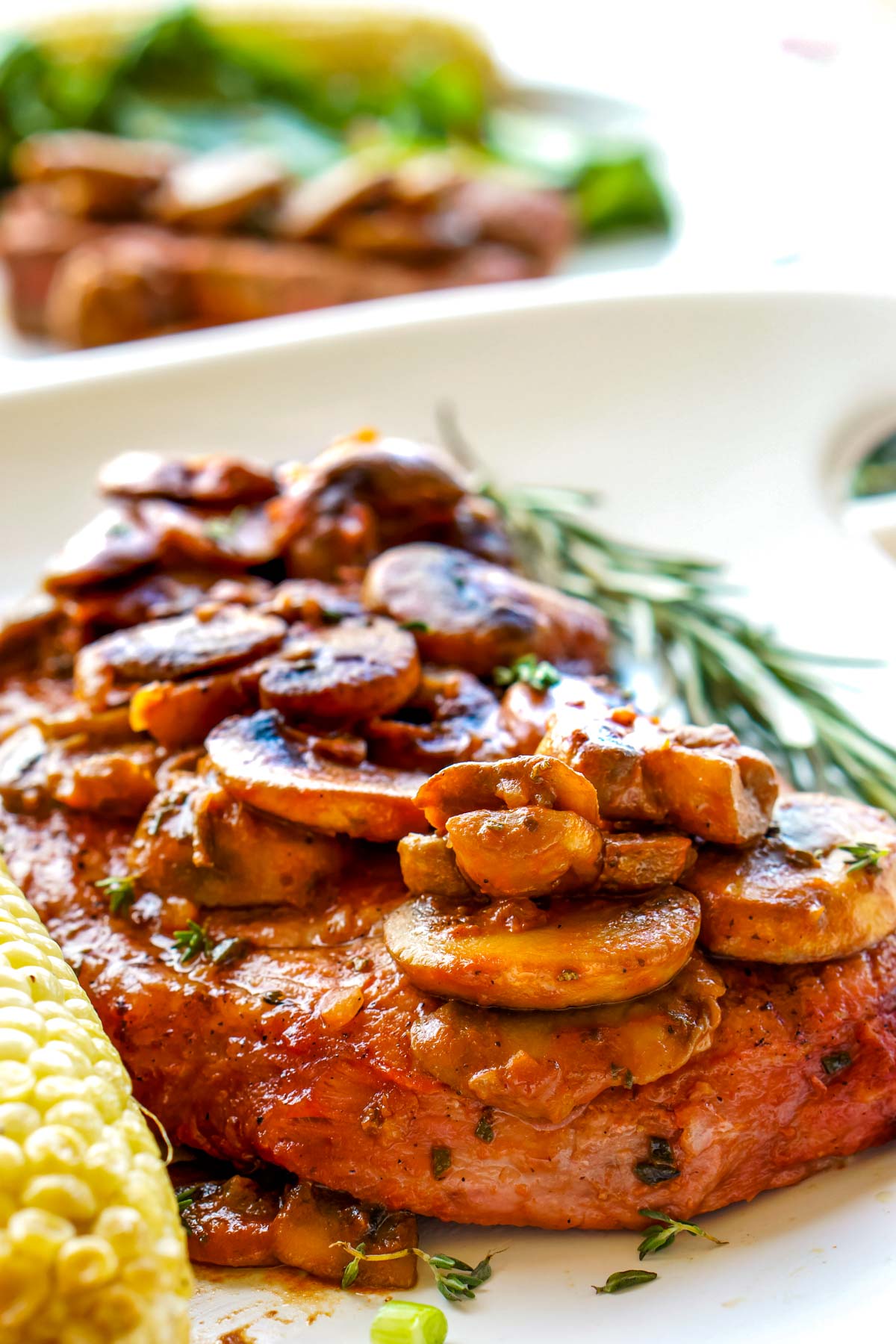 The finished Grilled Steak Marsala on a white plate topped with mushroom.