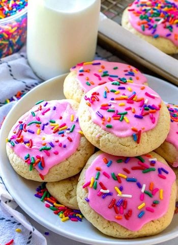 Round sugar cookie with pink frosting and rainbow sprinkles.