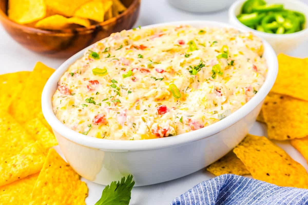 Baked Pimento Cheese Dip in a serving dish surrounded by tortilla chips.