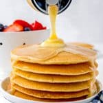 The finished Buttermilk Syrup recipe being poured over a stack of pancakes.