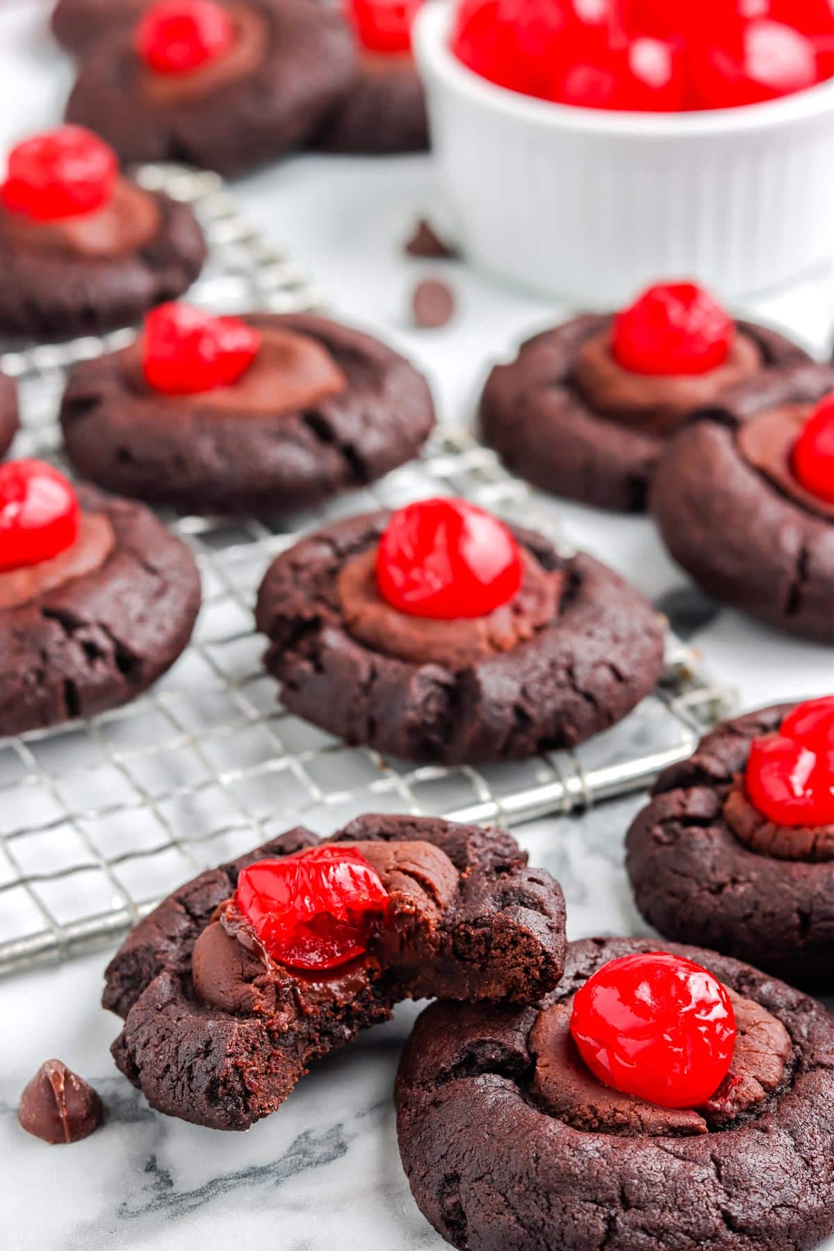 A close up picture of the finished Chocolate Covered Cherry Cookies recipe, one with a bite taken out of it.