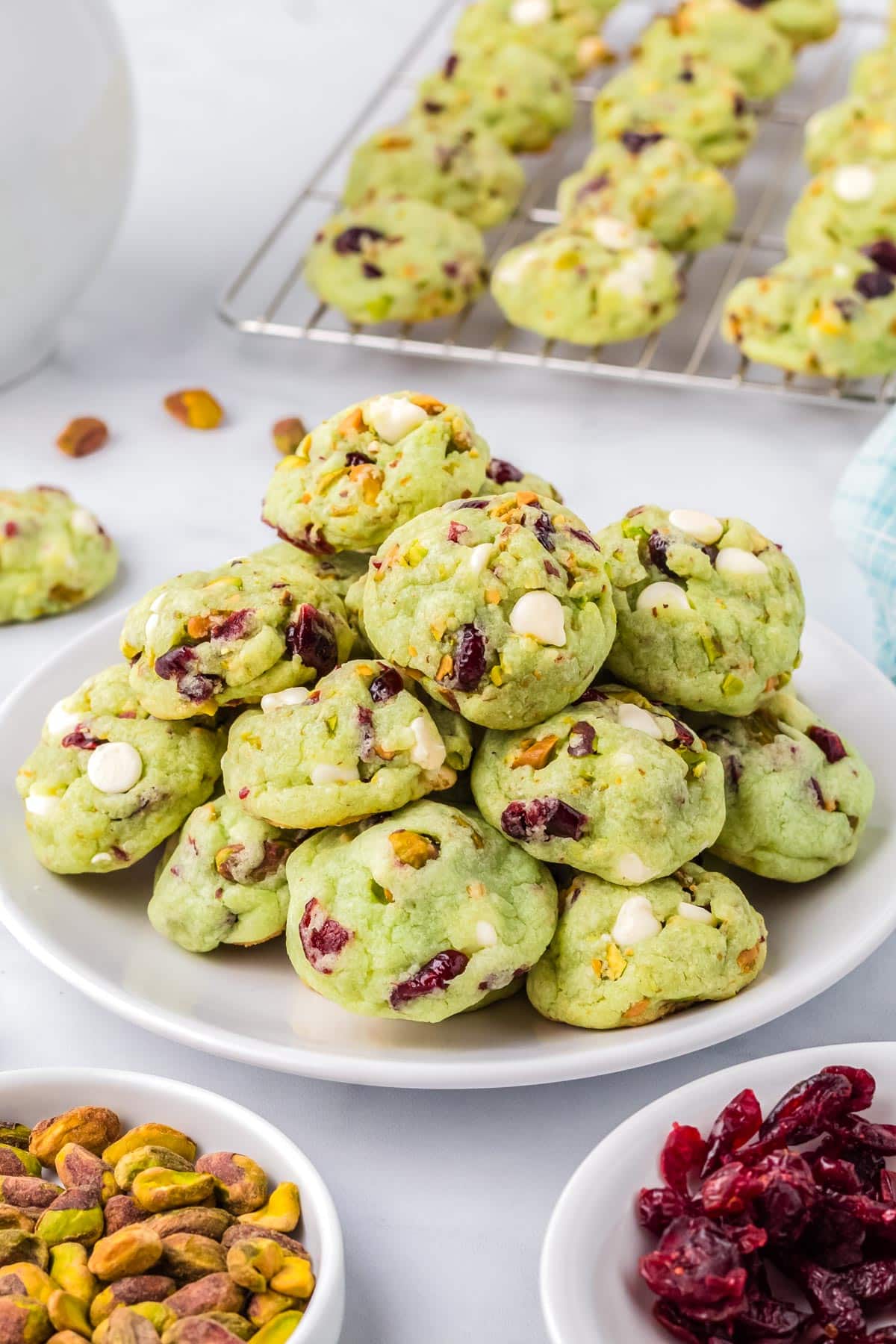 The finished Pistachio Pudding Cookies piled on a white plate. 