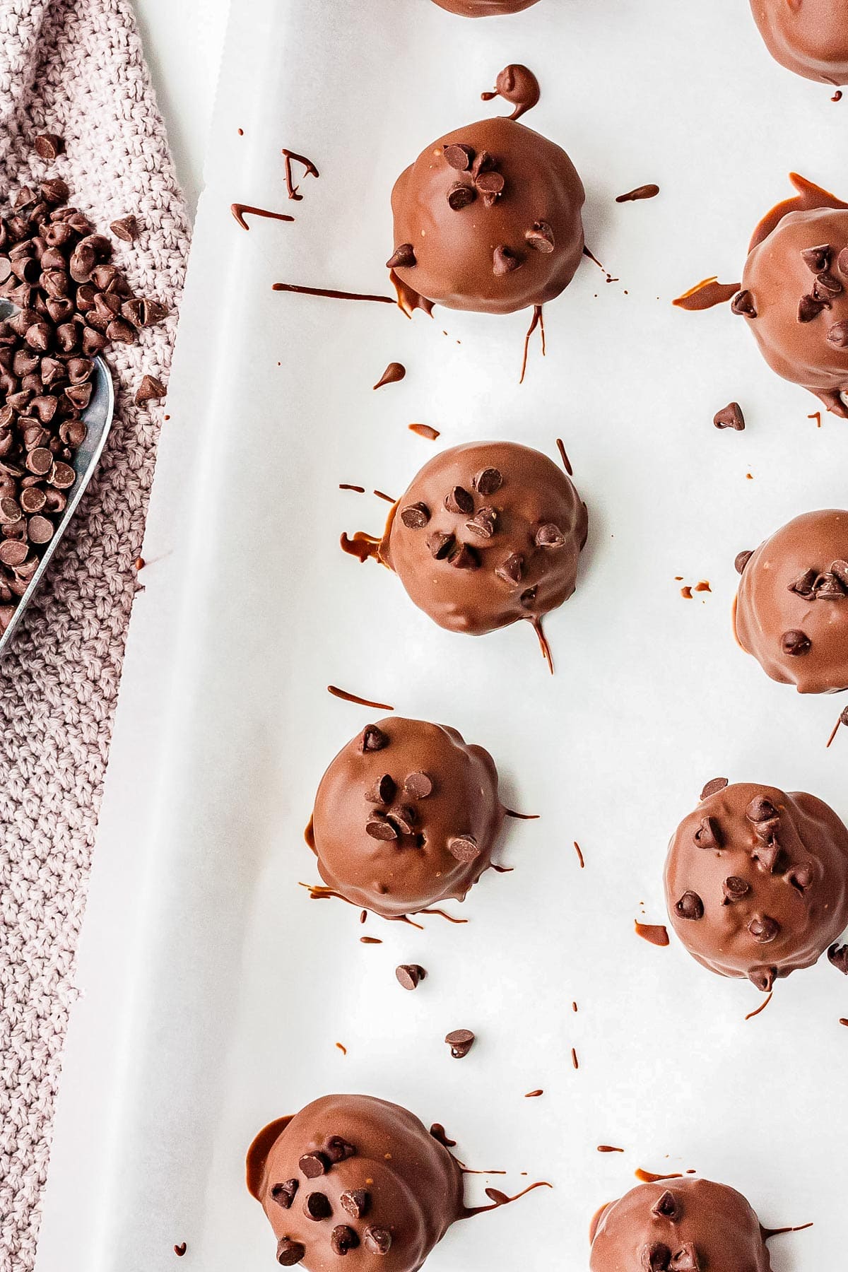 The finished chocolate chip cookie dough truffles on parchment paper.