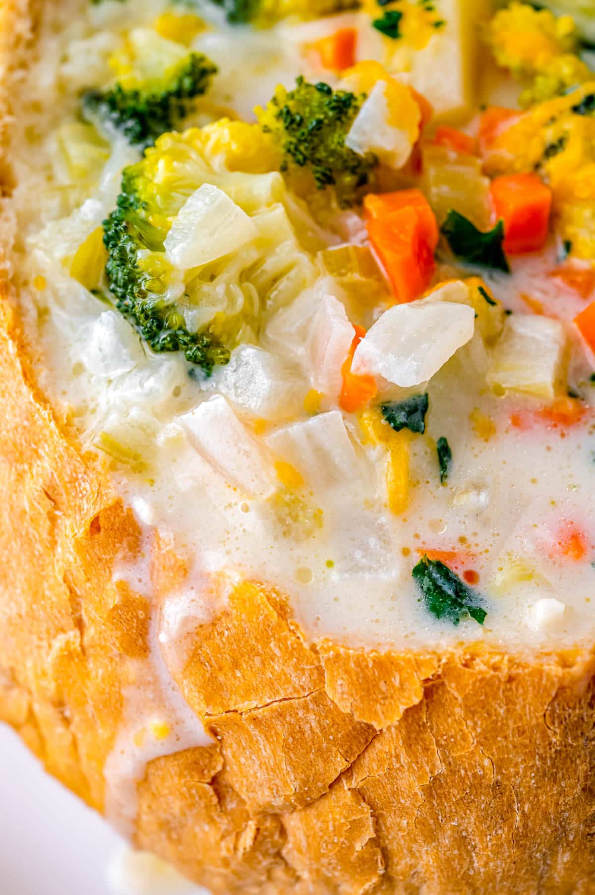 A close up picture of Creamy Vegetable Soup in a bread bowl.