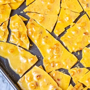 The finished recipe for peanut brittle on a baking sheet.