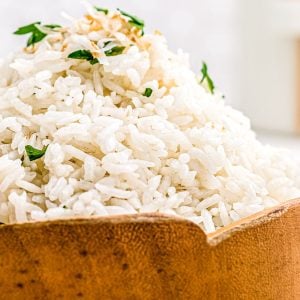 A close up picture of the finished Thai Coconut Rice in a wooden bowl.