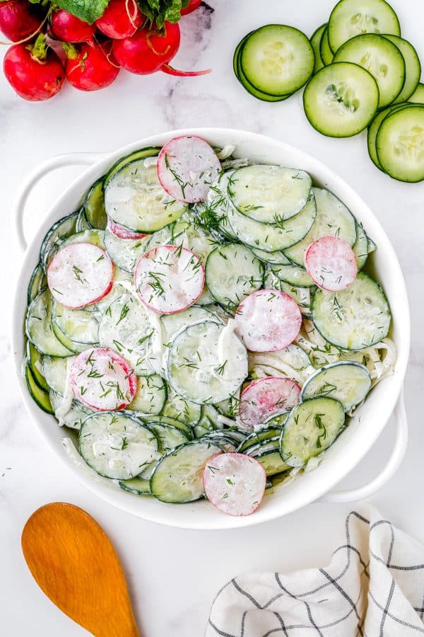 The finished Creamy Cucumber Salad in a white serving salad.