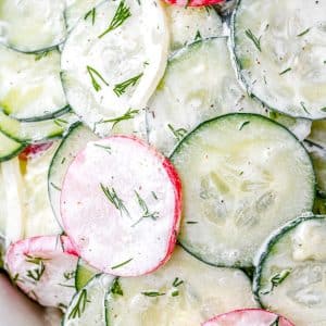 A close up of the finished Radish Cucumber Salad that's garnished with dill.