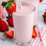 A glass filled with the strawberry smoothie with a strawberry garnish.
