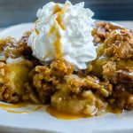 Apple Crisp on a plate with caramel sauce drizzled on top.