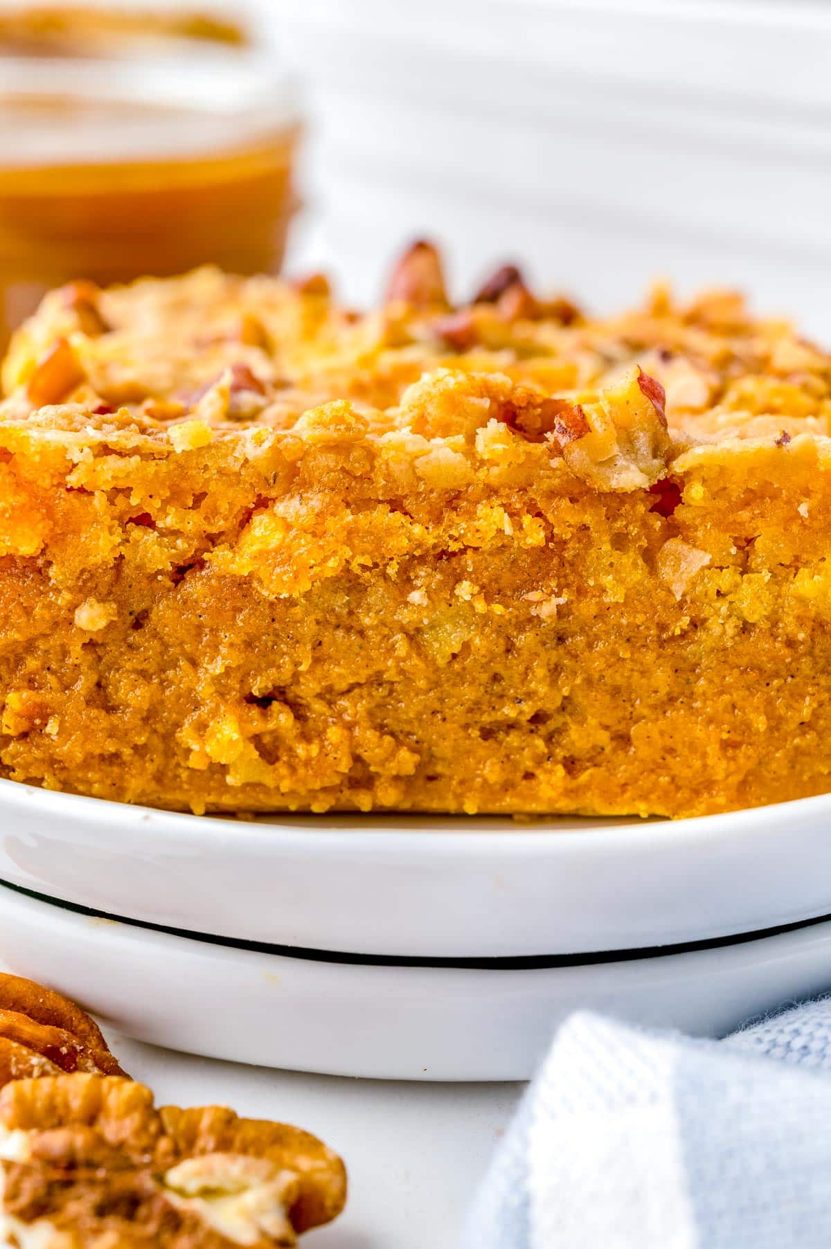 A close up picture of a slice of Pumpkin Dump Cake on a white plate.